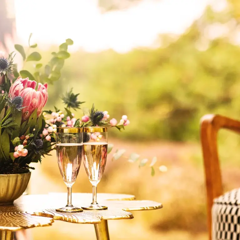 interiordesign-hamburg-goldener-tisch-mit-sektglas-und-blumen-smart-q-60